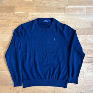 Mörkblå tröja från Polo Ralph Lauren - Säljer en klassisk mörkblå tröja från Polo Ralph Lauren i mjuk bomull. Tröjan har rund halsringning, långa ärmar och den ikoniska broderade loggan på bröstet.