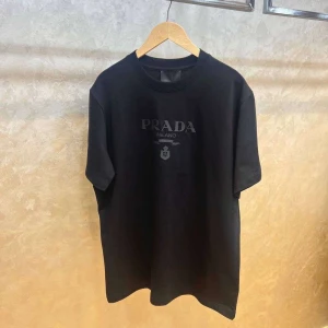 Svart t-shirt från Prada Milano - Svart t-shirt från Prada Milano med diskret logotryck på bröstet. Klassisk rund hals och korta ärmar. Stilren och enkel design som passar perfekt till jeans eller shorts. Materialet känns mjukt och bekvämt mot huden.