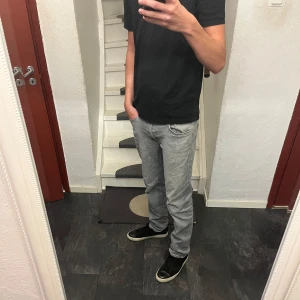 Grå raka jeansbyxor herr - Säljer ett par gråa jeans med regular fit från Jack and Jones som är i perfekt skick utan några defekter