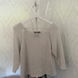 Beige stickad tröja från H&M - Säljer en ljusbeige stickad tröja från H&M med trekvartsärm och rund halsringning. Tröjan har en luftig stickning och avslappnad passform, perfekt för lager-på-lager. Enkel och stilren design som funkar till många outfits.