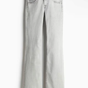 Ljusgrå bootcut jeans med låg midja - Snygga ljusgrå jeans med bootcut passform och låg midja. Jeansen har klassiska fem fickor och raka ben som blir bredare nedtill. Perfekta för dig som gillar en retro vibe och vill ha ett par jeans som sticker ut. Materialet är mjukt denim som sitter skönt hela dagen.