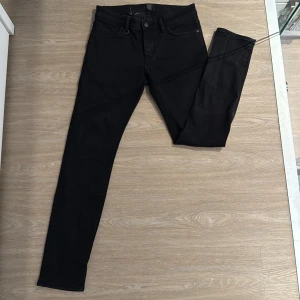 Svarta skinny jeans från Neuw - Svarta skinny jeans från Neuw med klassisk femficksdesign och diskret logga på bakfickan. Jeansen har en smal passform och är tillverkade i stretchigt bomullsmaterial för extra komfort. Perfekta för dig som gillar en stilren och modern look. Lite väl tajta på mig, jag väger 75kg och är 185cm✌️