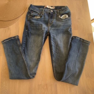 Levi's 510 Skinny jeans blå - Säljer ett par Levi's 510 Skinny jeans i klassisk blå tvätt. Jeansen har smal passform, fem fickor och snygga slitningar. De är tillverkade i jeansmaterial och har Levi's ikoniska läderpatch bak i midjan. Perfekta för dig som gillar en tajt look.
