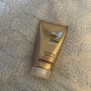 Dove Summer Revived Bronzer - Dove Summer Revived gradual self-tan för ansikte och kropp, ger en lätt till medium solkysst ton. Kommer i en snygg guld tub med vitt och brunt tryck. Perfekt för dig som vill ha en naturlig glow och jämn färg utan ränder. Använt endast ett få tal gånger💗
