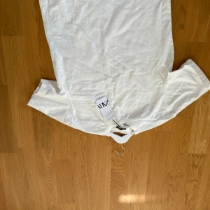 Vit t-shirt från Zara, storlek S - Fräsch vit t-shirt från Zara i storlek S. Klassisk rund halsringning och korta ärmar. Tillverkad i mjuk bomull som känns skön mot huden. Enkel och clean design utan mönster eller detaljer, perfekt för en chill och stilren look. Köpt för 229kr aldrig använd mitt pris 179kr.