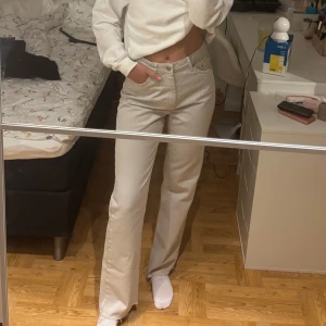 Ljusgråa raka jeans - Säljer ett par ljusgråa jeans från NA-KD med raka ben och fransiga kanter nertill. Byxorna har hög midja, klassiska fem fickor och är gjorda i bomull. Perfekta för en clean och avslappnad look. 