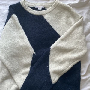 Stickad blåvit tröja från Gina Tricot - Säljer en stickad tröja från Gina Tricot i storlek 158/164. Tröjan har ett coolt mönster i mörkblått och vitt, med rund halsringning och långa ärmar. Perfekt för dig som gillar en stilren men ändå unik look.