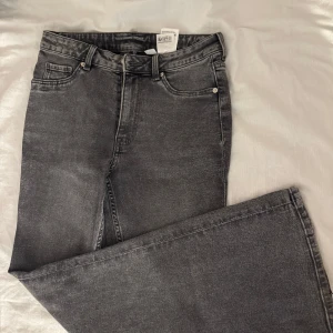 Grå bootcut jeans från H&M - Snygga grå jeans från H&M i bootcut-modell. Jeansen har klassisk femficksdesign, normalhög midja och är tillverkade i bomull med lite stretch för skön passform. Perfekta till sneakers eller boots. Är helt nya använda endast en gång. Pris kan diskuteras.