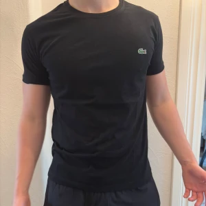 Svart t-shirt från Lacoste - Vanlig svart lacoste t-shirt. Tröjan är helt ny. säljer även ut andra saker från min gaderob så kolla gärna min sida och se om du hittar något du gillar!