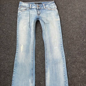 Lowrise Bootcut Jeans - Supercoola jeans i bra skick! En slitning baktill har öppnats lite men går lätt att sy tillbaka ”meshen” som täcker hålet alternativt bara ha öppet! Inga andra defekter utöver slitningar som ingår i designen😇💖 Jag är 160! Dem är stretchiga😇Innerben: 76cm Rakt över benöppningen: 22cm Grenhöjd: 18,8cm💖