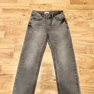 Grå raka jeans från Lindex - Snygga grå jeans från Lindex med klassisk femficksmodell och raka ben. Jeansen har normalhög midja och är tillverkade i mjukt denimtyg. Perfekta för en avslappnad och stilren look.