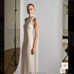 Champagnefärgad långklänning i silke - Nu säljer jag min vackra balklänning i äkta siden! Den är går ned till fötterna och är i färgen ”rå”, så den skiftar lite i färg beroende på ljus. Klänningen har en asymmetrisk hals med omlott-detalj och ett långt draperat axelband som faller ner längs ryggen. Köptes för 2800kr. Hör av er vid intresse eller för bilder med den på! Passar S/M💗