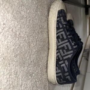 Fendi skor  - Här har vi ett par super snygga Fendi skor! Skorna har en färg som är speciell då det är en blandning mellan ljusblå och mörkblå F som är symbolen för Fendi. Man ser att det är ett par högprofilerade skor som man har på fötterna på långt avstånd. Jag har använt dem under sommaren men tröttnat på dem som jag gör med alla mina skor. Strl 44 