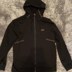 Hugo boss kofta - Guld och svart Hugo boss zip hoodie. Som ny. Nypris 2000kr. Storlek L men kan passa M. Pris kan diskuteras vid snabb affär