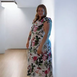 Blommig långklänning från Bodyflirt - Säljer en superfin långklänning från Bodyflirt med färgglatt blommönster i rosa, grönt och rött på vit botten. Klänningen har volangdetalj upptill och är ärmlös med breda axelband. Perfekt för sommarens alla tillfällen!