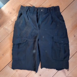 svarta cargo shorts - ett par längre svarta cargo shorts med fickor!sitter ganska tight i midjan^^