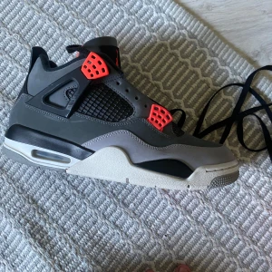 Nike Air Jordan 4 infered kvitto finns. Skorna är köpta på someplus - Säljer ett par Nike Air Jordans sneakers i grått och svart med röda detaljer. Skorna har en klassisk siluett, meshpaneler på sidorna och synlig luftdämpning i sulan. Perfekta för dig som gillar streetwear och vill sticka ut med snygga färgdetaljer.