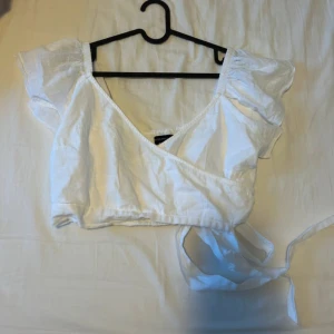 Vit topp - Vit topp med kort puffärm och knytband, så om du har mindre strl kan du anpassa med dessa. Aldrig använd. Väldigt kort 