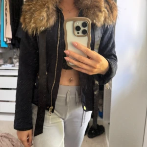 Jacka med pälskrage - Säljer en marinblå jacka från Zara med stor brun päls runt kragen från Raglady. Jackan har dragkedja, knappar och två fickor framtill med dragkedjor. Snygg passform och långa ärmar. Pälsen har jag sytt på, men går lätt att ta av. 
