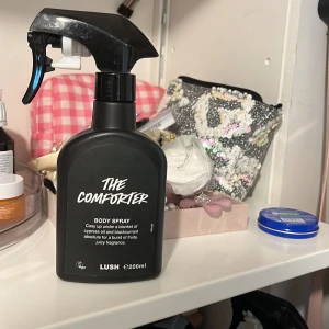 The Comforter Body Spray från Lush helt ny oanvänd  - helt ny oanvänd Säljer en The Comforter body spray från Lush i svart sprayflaska, 200 ml. Doften är fruktig med inslag av cypress och svartvinbär. Perfekt för dig som gillar söta och bäriga parfymer.