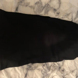 Svart kjol - Säljer en svart stretchig kjol med mjuk och stretchig känsla. Perfekta för dig som gillar en bekväm och stilren look. Kjolen har en enkel design utan synliga detaljer och passar till många olika outfits.