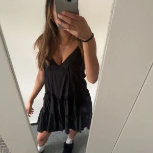 Svart volangklänning med v-ringning - Säljer en svart kortklänning med v-ringning med volang detaljer. Perfekt inför sommaren! Jätte söt och fin!!