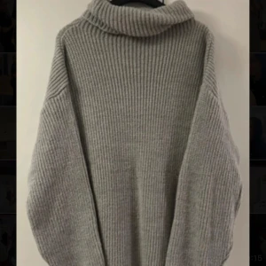 Grå stickad polotröja - Säljer en oversized grå stickad polotröja med bred ribbstickning. Tröjan har lång ärm och hög polokrage, perfekt för kyliga dagar. Supermjuk och skön att ha på sig.