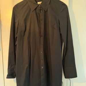 Svart skjorta från ONLY - Klassisk svart storskjorta från ONLY med lång ärm och knappar framtill. Längre modell. 