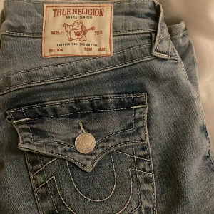 True Religion Becca Bootcut Jeans - Snygga ljusblå jeans från True Religion, modell Becca. Klassisk med bootcut-snitt. Passar till allt. Använt 3 ggr då köpta i fel storlek. Köpta direkt i affären på carlings för  Ordinarie pris 1299. Jättebra skick. Pris kan diskuteras vid snabb affär 
