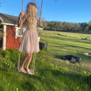 Ljusrosa tyllklänning med spetsliv - En gullig klänning som passar flera storlekar, personen på bilden har storlek är ca 140 cm men kan användas upp till ca 152 cm. Den har en vi tyllkjol och en rosa underkjol. Tyllkjolen har en liten trasig del men det är inget som syns så mycket och vill man så kan man ju klippa bort den delen. Använd få gånger. Titta gärna till på min Vinted ”estridgavmigtips” där denna klänning också är publicerad. Hör av er vid frågor!🌸