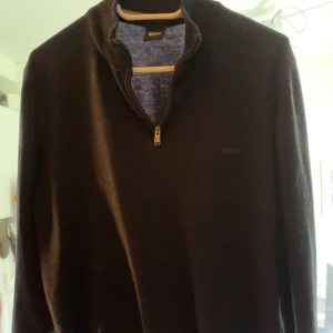 Svart halfzip tröja från BOSS - Säljer en svart långärmad tröja från BOSS med halv dragkedja vid halsen. Tröjan har en stilren design och är perfekt för en avslappnad men snygg look. Nypris cirka 2000