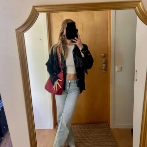 Svart jeansjacka med detaljer - Säljer en svart jeansjacka med coola fransdetaljer framtill. Jackan har knappar och en oversized passform. Fått massa fina komplimanger med denna!
