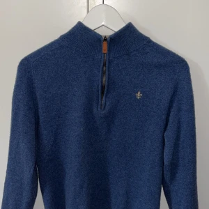 Blå tröja med half zip från Morris - Säljer en stilren blå tröja från Morris med half zip. Tröjan har en liten broderad logga på bröstet och kontrastfärgad insida vid kragen. Perfekt för kyliga dagar. Storlek M men passar bättre som S. Ett litet hål mellan en av armarna men det märks inte! Bara att höra av sig vid frågor 
