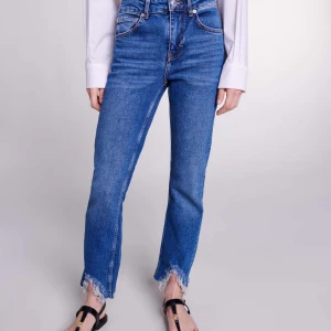 Ljusblå jeansbyxor från Maje - Ljusblå jeansbyxor från Maje med klassisk femficksdesign och raka ben. Jeansen har en snygg tvättad look och orangea sömmar som kontrast. Perfekta för en avslappnad och trendig stil. Nypris ca. 1800kr. 