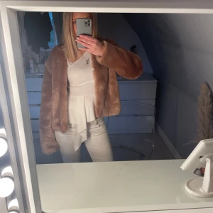 Rosa pälsjacka från Soft Rebels - Säljer en supermjuk och fluffig rosa pälsjacka från Soft Rebels. Jackan är öppen framtill med 6 hakar för att knäppa och har en slät, silkeslen, ljusrosa insida. Perfekt för dig som vill ha en trendig och mysig look. Har använd vid enbart 2 tillfällen.