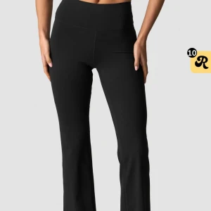 Utsvängda träningstights  - Snygga svarta utsvängda träningstights. Byxorna har en slät och enkel design utan synliga detaljer, vilket ger en stilren look. Perfekta för en trendig och bekväm stil.