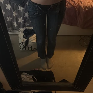 Mörkblå jeans med låg midja och raka ben - Säljer ett par mörkblå jeans med låg midja och raka ben. Jeansen har klassiska fickor fram och bak, samt knappar i gylfen. Snygga kontrastsömmar och diskreta slitningar. Jag är 176 cm och de är för korta för mig, de är ifrån Gina för längesedan så de finns ej att köpa längre. Bara att skriva om frågor💕de står ej någon storlek i de, men jag brukar ha storlek 38 i jeans och de passar ej 