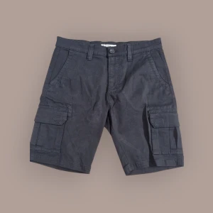 Svarta cargoshorts från Hangten - Svarta cargoshorts från Hangten med klassiska sidofickor och bälteshällor. Stängs med knapp och dragkedja. Perfekta för sommardagar när du vill ha en avslappnad stil och praktiska fickor.