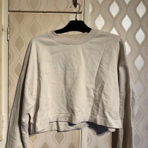 Beige croppad sweatshirt - Säljer en beige croppad sweatshirt med rund halsringning och långa ärmar. Storlek L men känns som M