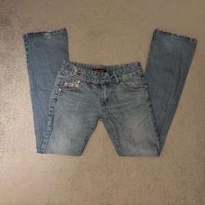 Super jeans ljusblå bootcut jeans - Ljusblå jeans från Super Jeans som är lågmidjade och bootcut. Jeansen har super snygga detaljer vid fickorna och är i storlek w26 l40 !! Hör av er om ni har några frågor💗