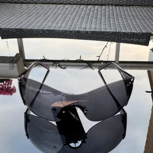 NYA Svarta transparenta solglasögon - Säljer ett par svarta transparenta NYA solglasögon med breda bågar. Glasögonen har en futuristisk, sportig design. Hämtas i Hägersten. 