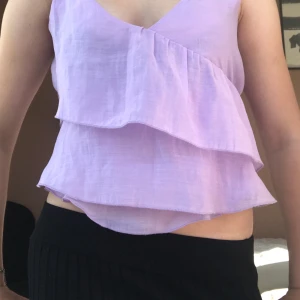Ljuslila volangtop från H&M - Superfin puffig ljuslila topp från H&M med  volanger och v-ringad omlottfront. Tunn och luftig känsla, perfekt för varma dagar. Tunna och justerbara axelband. Öppen för prisförslag och skriv för frågor 🥰