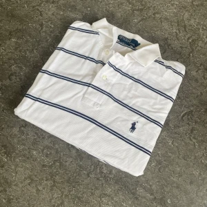 Vit randig pikétröja från Ralph Lauren - Säljer en vit piké från Polo Ralph Lauren med mörkblå ränder. Hör av dig vid frågor, priset kan diskuteras.  🧵 Skick: Mycket bra 📏 Storlek: L 🎨 Färg: Vit, Mörkblå 🏷️ Märke: Polo Ralph Lauren