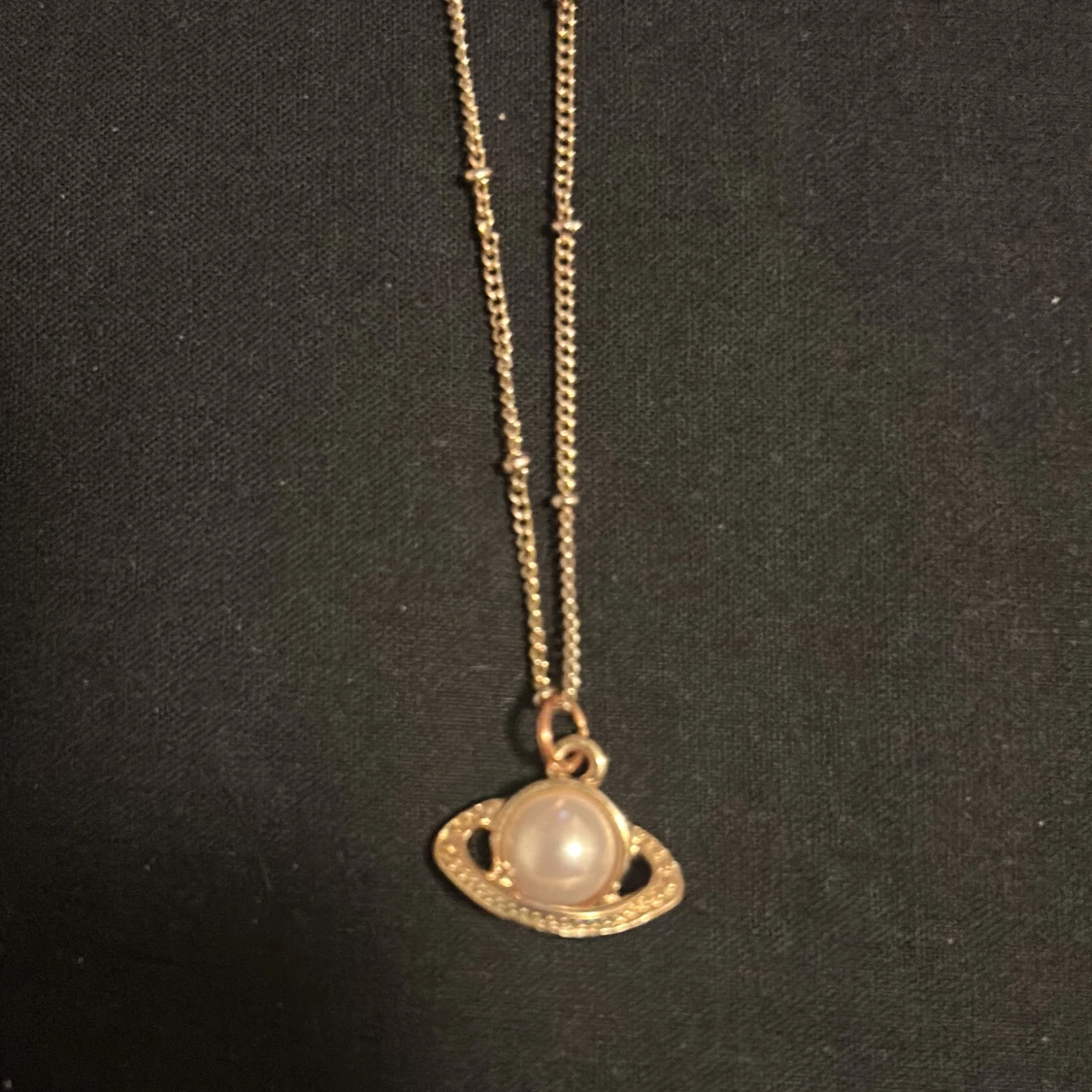 Guldigt halsband med planetberlock