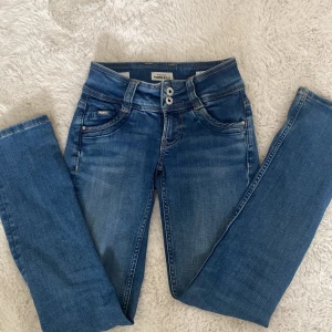 Blå straight jeans från Pepe Jeans - Snygga blå jeans från Pepe Jeans med rak passform och midwaist. Klassisk femficksdesign, dubbla knappar i midjan och coola detaljer på bakfickorna. Jeansen är är stretchiga och tvättade kanske 1-2 gånger. Har använt de 3 gånger ungefär så de är inte alls slitna och ser ut som nya. Köpte de för 900💕💕 