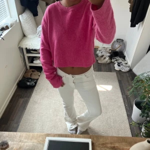 Croppad rosa stickad tröja - Säljer en croppad stickad tröja i en härlig rosa färg. Tröjan har lång ärm och rund halsringning, perfekt för dig som gillar en chill och trendig stil. Mjuk och skön känsla, passar till både jeans och kjol.