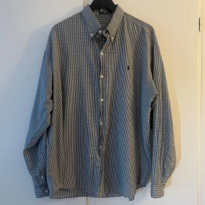 Ralph Lauren Skjorta - Klassisk blårutig skjorta från Polo i 100% bomull. Storlek XL, väldigt mjuk och bekväm. Bra skick förutom ett litet hål på vänster armbåge, se bild.