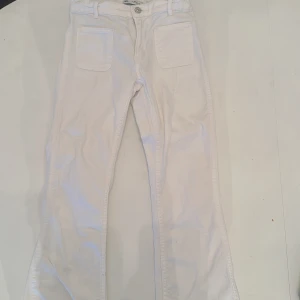 Vita bootcut byxor från Zara - Säljer ett par vita bootcut byxor från Zara i storlek 152 (12-13 år) står 13-14 år men de är mindre. Byxorna har två stora fickor fram och två bak, samt bälteshällor och knappstängning. Perfekta för en fräsch och stilren look.