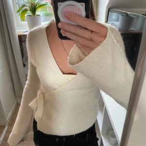 Vit omlottkofta från Gina Tricot - Vit stickad omlott tröja från Gina tricot. Säljer på grund av att den inte kommer till användning, har använt fåtal gånger!♥️