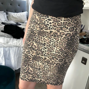 Leopardmönstrad tight kjol från New Yorker - Säljer en tight kjol med leopardmönster i beige och bruna toner från New Yorker. Kjolen är knälång med en liten slits bak och har en kroppsnära passform. Perfekt till sommaren! Använt många gånger men ser fortfarande bra ut! ❤️